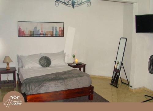 1 dormitorio con 1 cama, 2 mesas y TV en Full house, 11BR, 12BA, 10 min from SJO Airport, en Heredia