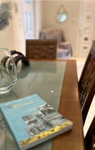 a book sitting on top of a wooden table at Άνετο διαμέρισμα στο κέντρο της πόλης in Aegina Town