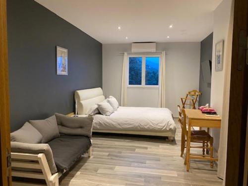 a living room with a bed and a couch at La Villa Volpaso in Belgodère
