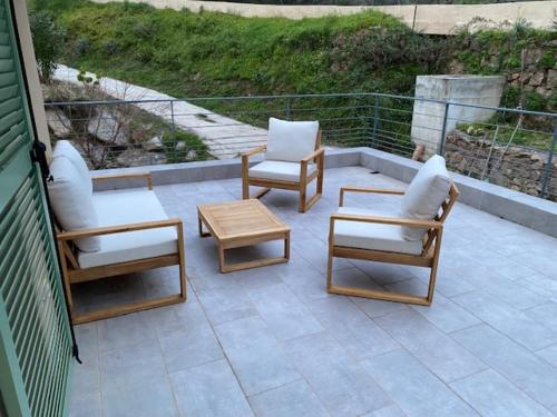 a patio with two chairs and a table and two chairs at La Villa Volpaso in Belgodère