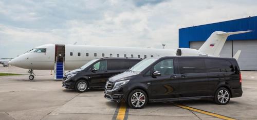 two vans are parked next to an airplane at Lotus Airport Hotel in İmrahor