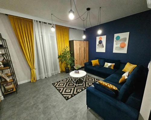 a living room with a blue couch and a table at Apartamenty Nowickiego in Lublin