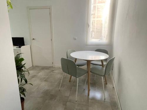 a dining room with a white table and chairs at San Buenaventura Vistillas apartamento para dos in Madrid