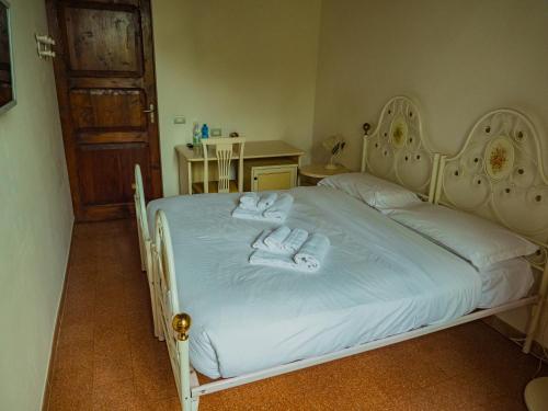 a bedroom with a white bed with towels on it at B&B Villa Erika in Lugo