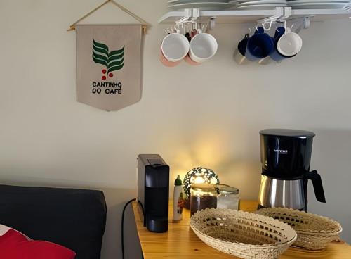 einen Tisch mit Kaffeemaschine und Tassen darauf in der Unterkunft Casinha na Represa 2 in CÃ¡ssia