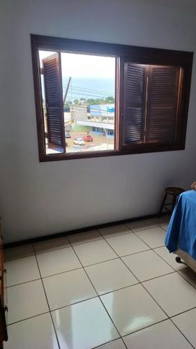 een kamer met een raam en een tegelvloer bij Quarto c/ Ar Split 01 cama casal , banheiro social compartilhado ( fora do quarto ) in Tabapira