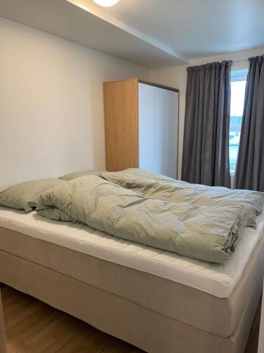 duże łóżko w sypialni z oknem w obiekcie Helt ny leilighet w mieście Leknes