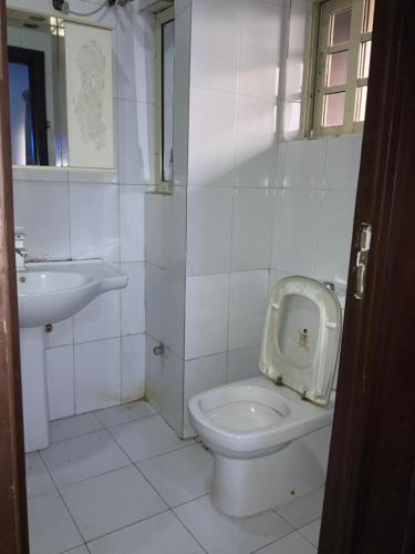 a white bathroom with a toilet and a sink at NEW VIEW BEACH HOTEL AND RESORT in Lagos