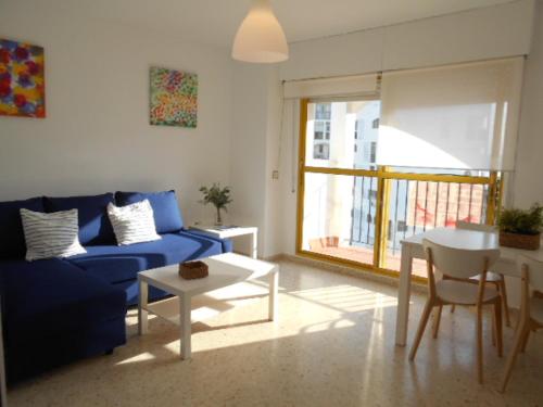 - un salon avec un canapé bleu et une table dans l'établissement Navegante, à El Puerto de Santa María