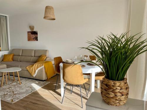 a living room with a couch and a table with a plant at RosaMar in Albufeira