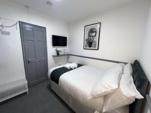 ein Schlafzimmer mit einem Bett mit einem Schwarz-Weiß-Foto an der Wand in der Unterkunft OYO Greenway Stays in Uxbridge