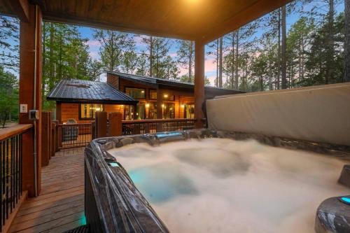 a hot tub on a deck in front of a house at Ember Skye Cabin - 2 bdr & Bunk Nook/2.5 bath in Broken Bow