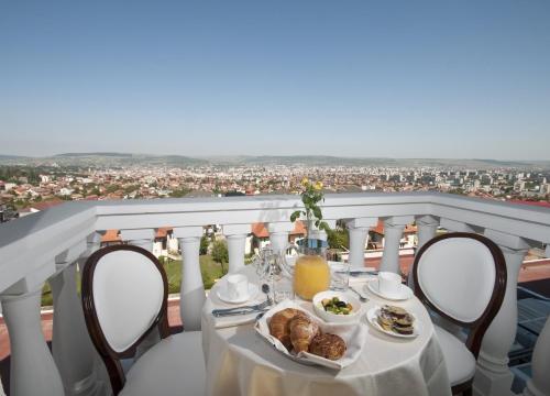 a table with a plate of food on a balcony at Grand Hotel Italia in Cluj-Napoca