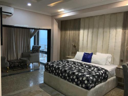 a bedroom with a bed and a chair in a room at NEW VIEW BEACH HOTEL AND RESORT in Lagos
