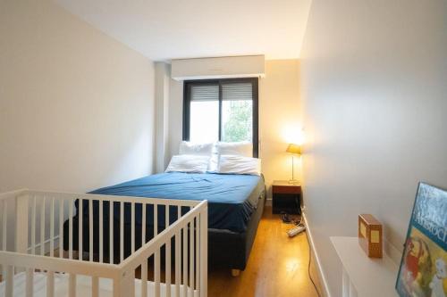 une petite chambre avec un lit et une fenêtre dans l'établissement Julian's house charmant 3 pièces, à Levallois-Perret