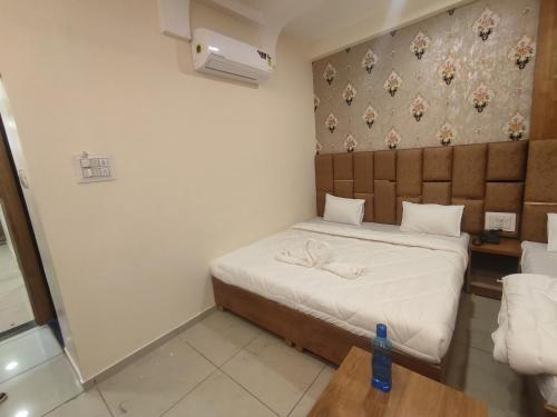 ein kleines Schlafzimmer mit einem Bett und einem Kopfteil aus Holz in der Unterkunft The prime hotel in Ujjain