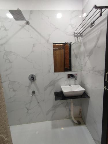 y baño blanco con lavabo y ducha. en The prime hotel en Ujjain
