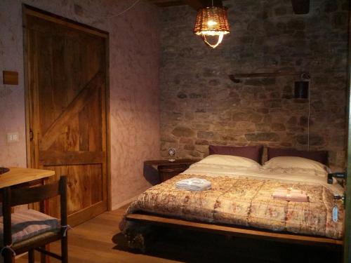 1 dormitorio con 1 cama con pared de piedra en Sasso Erminia R&B Ecosostenibile en Novafeltria