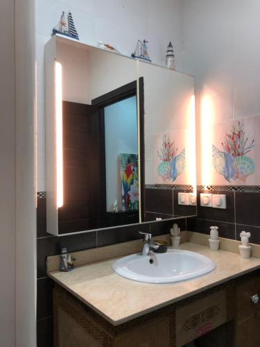 a bathroom with a sink and a mirror at Tamaris Résidence les jardins Apparemment haut standing moderne et élégant 77 m in Casablanca