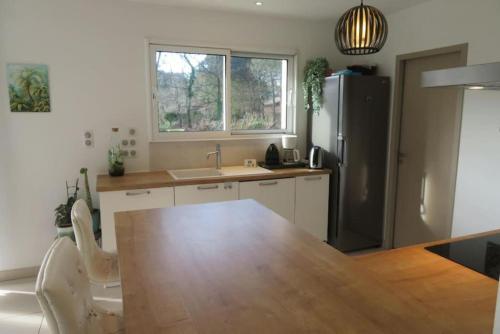 une cuisine avec une table en bois et un réfrigérateur dans l'établissement Villa idéale séjour en famille à Taussat, à Lanton