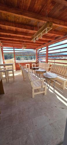 a picnic table and benches in a pavilion at Sarajevo NATURE Romanija in Sarajevo