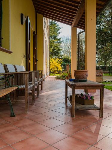 a patio with benches and a table on a building at B&B Villa Erika in Lugo