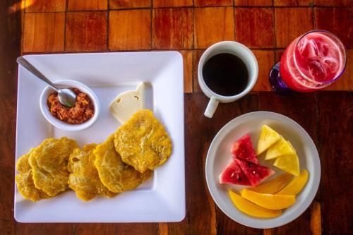 a plate with eggs and fruit and a cup of coffee at Isla Los Erizos EcoHouse in Isla Grande