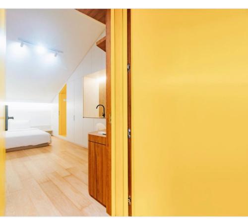 Habitación con puerta amarilla y dormitorio en Social-Inn Norris Road Apt en Singapur