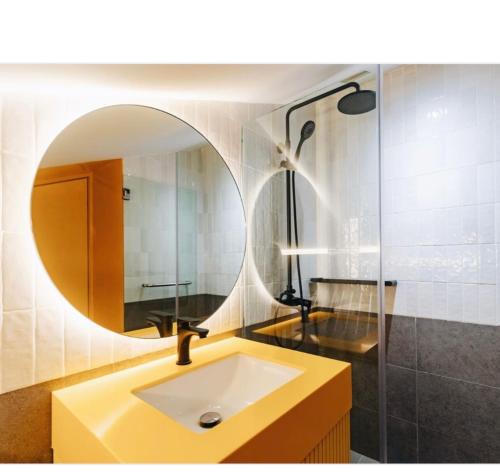 a bathroom with a sink and a mirror at Social-Inn Norris Road Apt in Singapore