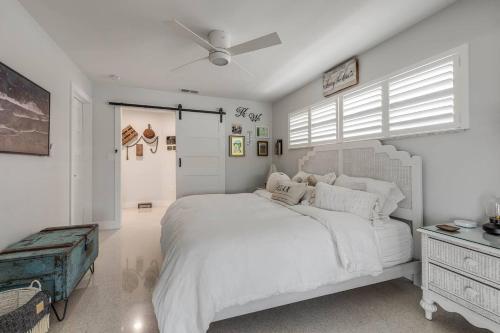 a white bedroom with a large bed and a window at The Pearl - Pool W Screen On Canal - Boat Rental in Cocoa Beach