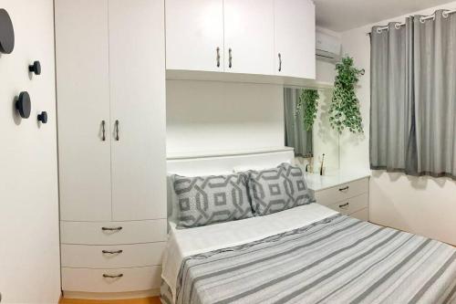 a bedroom with a bed and white cabinets at Lindo Apartamento na praia de Ponta de Campina in Cabedelo