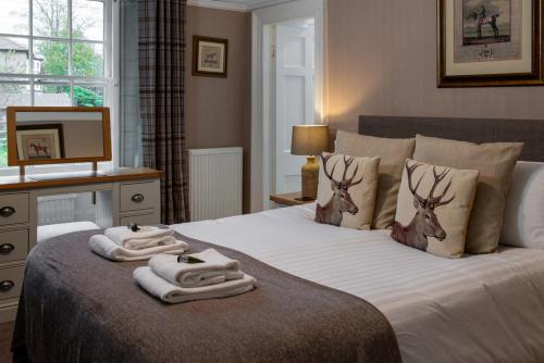 um quarto com uma cama com toalhas em Harts Head Hotel em Settle