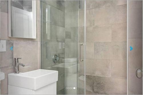 a bathroom with a shower with a toilet and a sink at Premier Suites Bay Village in Boston