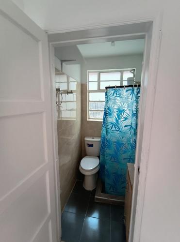 a bathroom with a toilet and a shower curtain at Casa portón negro in Bogotá