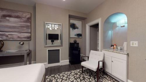 a bedroom with a bed and a desk and a chair at Premier Suites Bay Village in Boston