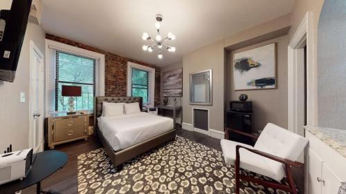 a bedroom with a bed and a chair in a room at Premier Suites Bay Village in Boston