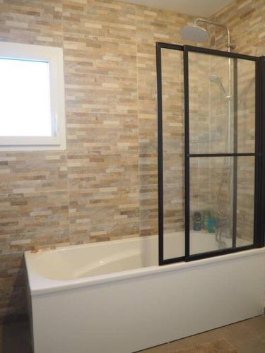 une salle de bain avec une baignoire et une fenêtre dans l'établissement Maison 6-8 personnes 3 chambres, aux Pieux
