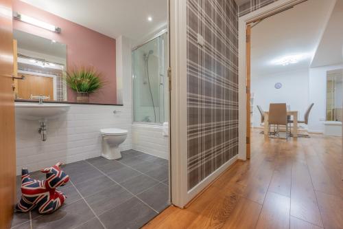 a bathroom with a sink and a toilet and a mirror at AC19 Lower North Aisle - Luxury Self Catering 2 Bedroom Apartment in Fort Augustus