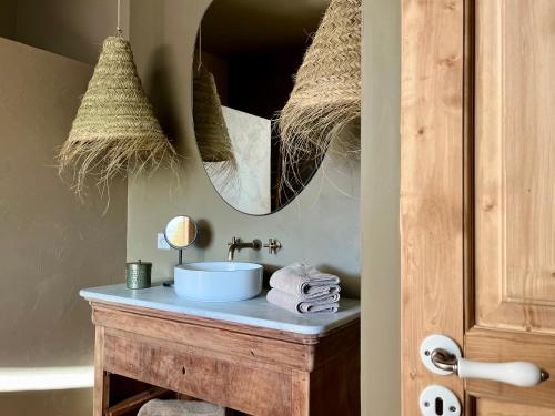a bathroom with a sink and a mirror at Les Terrasses de Bélarga - Maison d'hôtes - Piscine et Jacuzzi in Bélarga