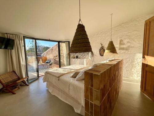 1 dormitorio con cama y ventana grande en Les Terrasses de Bélarga - Maison d'hôtes - Piscine et Jacuzzi, en Bélarga