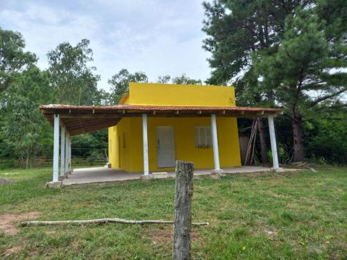 une petite maison jaune dans un champ dans l'établissement Casa da Vigia, à Santana do Livramento