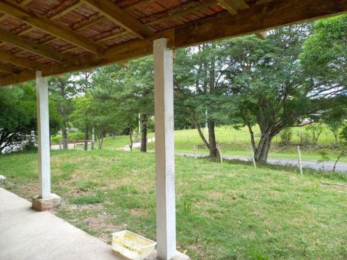 une terrasse couverte avec un poteau dans un champ arboré dans l'établissement Casa da Vigia, à Santana do Livramento