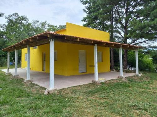 un bâtiment jaune avec toit sur un champ dans l'établissement Casa da Vigia, à Santana do Livramento
