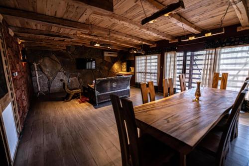 a dining room with a wooden table and chairs at Hotel Xaluca Dades in Boumalne