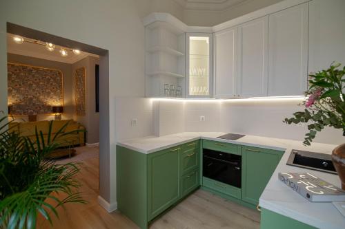 a green and white kitchen with white cabinets at Chrobrego Residence in Gniezno