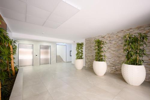 a hallway with three large white pots with plants in them at Charming Hideaway Inspired by El Profesor's Intrigue in Bucharest