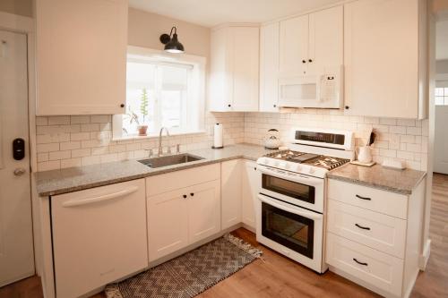 a kitchen with white cabinets and a stove and a sink at The Heritage House in Klamath Falls