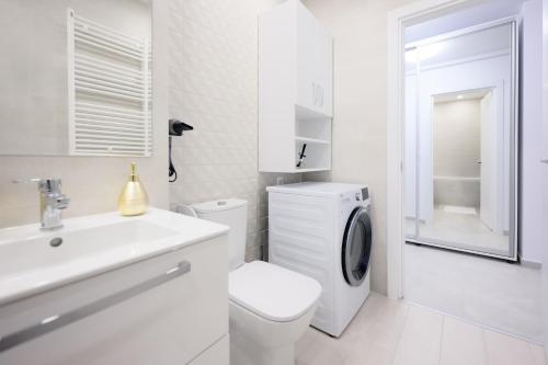 een witte badkamer met een toilet en een wastafel bij Charming Hideaway Inspired by El Profesor's Intrigue in Boekarest
