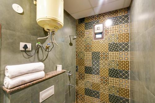 W łazience znajduje się prysznic ze szklanymi drzwiami. w obiekcie Roseewood Hotel Near Delhi International Airport w Nowym Delhi