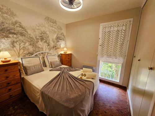 a bedroom with a large bed and a window at Logis des Palmiers YourHostHelper in Gruissan